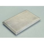 A large silver cigarette case of slide opening design with engine turned decoration, 13cms high.