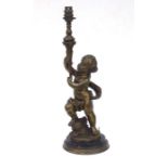 A large French bronze and marble figural table lamp in the form of a cherub holding a torch aloft,