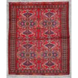 A Persian Gonbad rug with butterfly design within stylised borders, on a red ground, 185 by