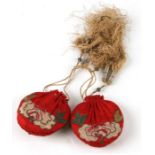A pair of Chinese red silk purses with embroidery and silver bullion wire tassels (2).