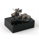 A white metal miniature group depicting a picador and bull on a black base, overall 5cms wide.