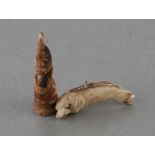 A 19th century Inuit marine ivory carved dolphin, 4cms long; together with a Tupilac pendant (2).