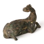 A Chinese silver inlaid and parcel gilt bronze recumbent mythical beast, 16cms wide.