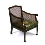 An early 20th century bergere chair with upholstered seat and caned sides and back.