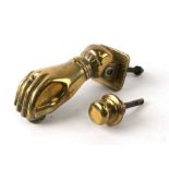 A brass hinged door knocker in the form of a ladies hand, 15cms long.Condition ReportMeasures 6cms