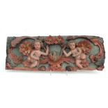 A large painted oak relief carved panel depicting cherubs and flowers, probably 16th / 17th century,