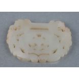 A Chinese carved jade buckle, the carved decoration depicting dragons and bats.