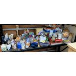 SHELF OF ORNAMENTS, EARTHENWARE FLAGGONS, ENAMEL BREAD BIN, PLATES ETC