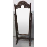 A 20th century stained oak cheval mirror, with carved decoration and shaped stretcher, 148cm high