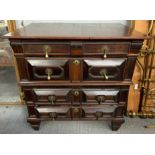 An 18th century oak chest of four long drawers, in two sections, the geometrically moulded drawers