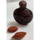 A carved snuff bottle, along with two carved nuts