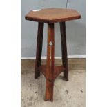 An oak Arts and Crafts occasional table with hexagonal top to three tapering shaped legs with cut