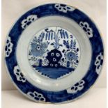 A blue and white Delft plate, decorated with plants and flowers, 23.5cm diameter