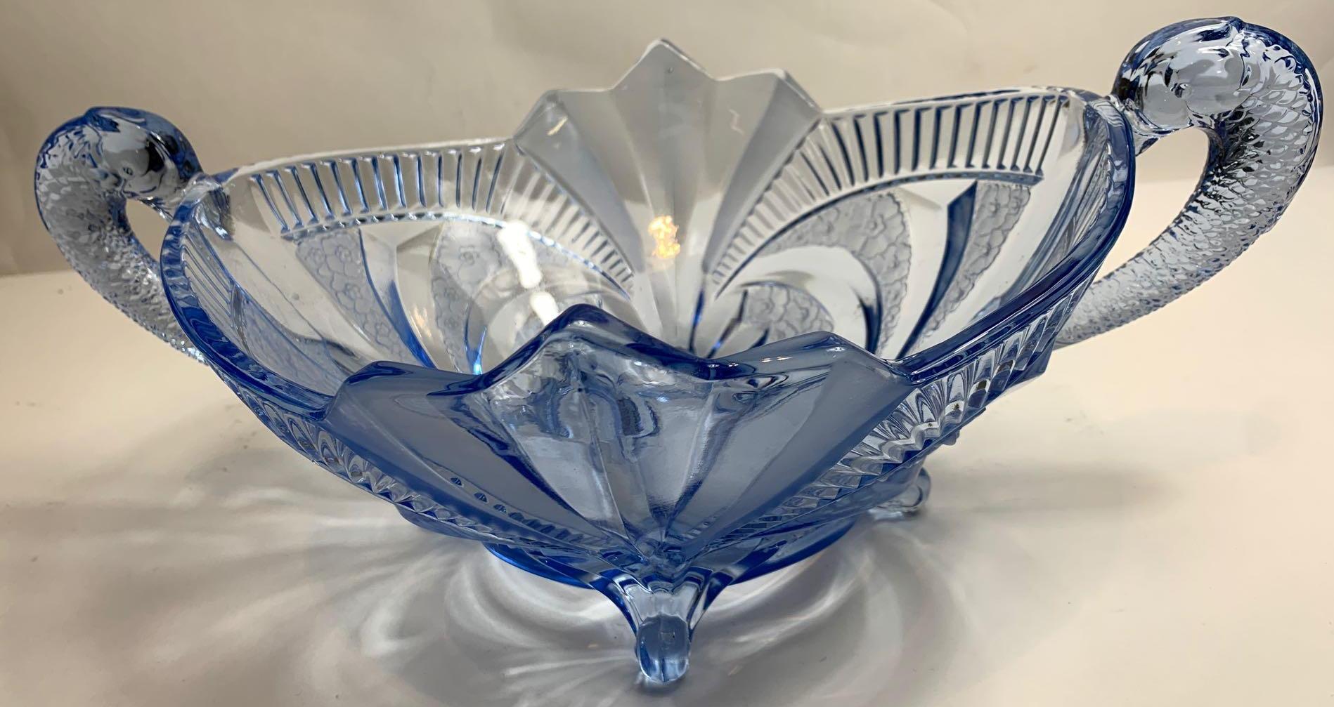 An Art Deco moulded blue glass centre piece, with fish handles standing on four scrolled feet,