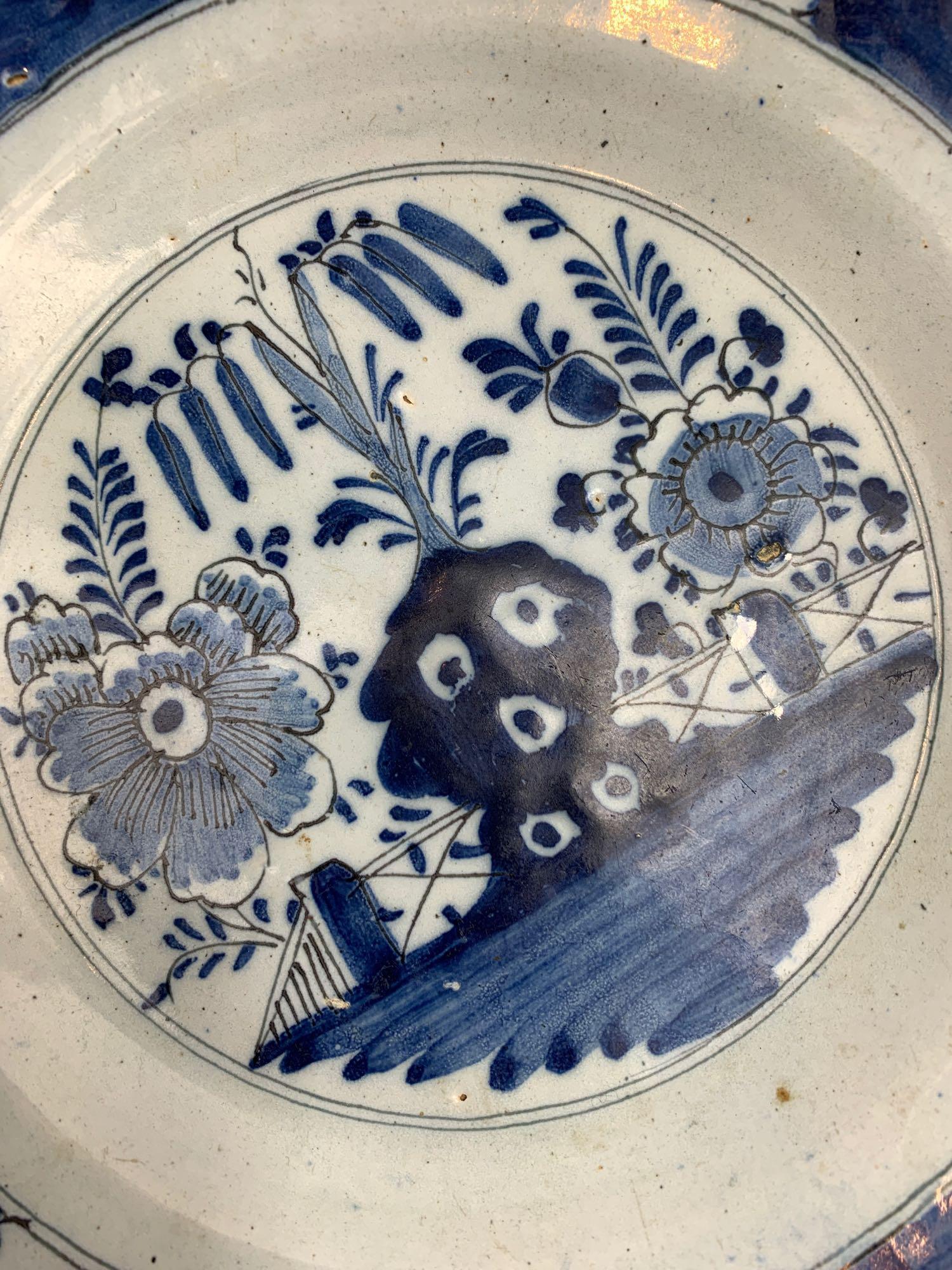 A blue and white Delft plate, decorated with plants and flowers, 23.5cm diameter - Bild 2 aus 3
