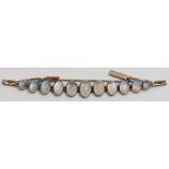 A moonstone bracelet, the eleven graduated cabochons in unmarked yellow metal, probably from