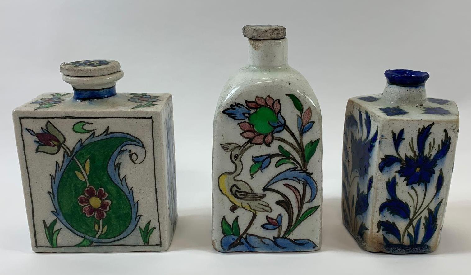 Three Turkish Iznik/Persian pottery flasks, two decorated with various flowers, plants and