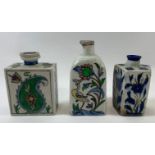 Three Turkish Iznik/Persian pottery flasks, two decorated with various flowers, plants and