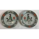 A pair of Chinese plates each decorated with a seated lady, with stylised border decorated with