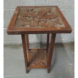 A 20th century two tier oak occasional table, the top decorated with acorn and oak leaf carving