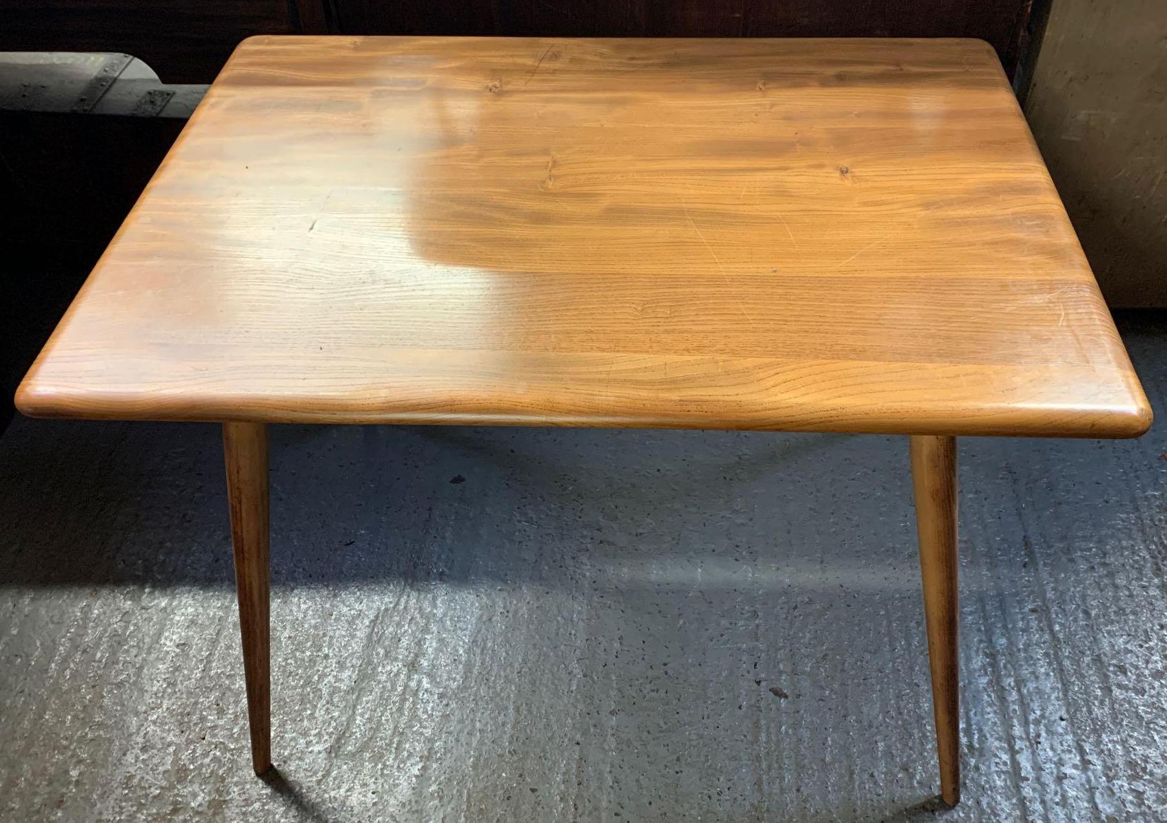 A mid 20th century Ercol beech and elm rectangular breakfast table, with slatted under tier to the