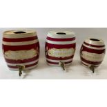 A white and burgundy striped ceramic spirit barrel with brass tap, labelled 'Nouveau', 33cm high;