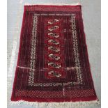 A silk rug with central rectangle decorated with diamond pattern surrounded by repeating borders,