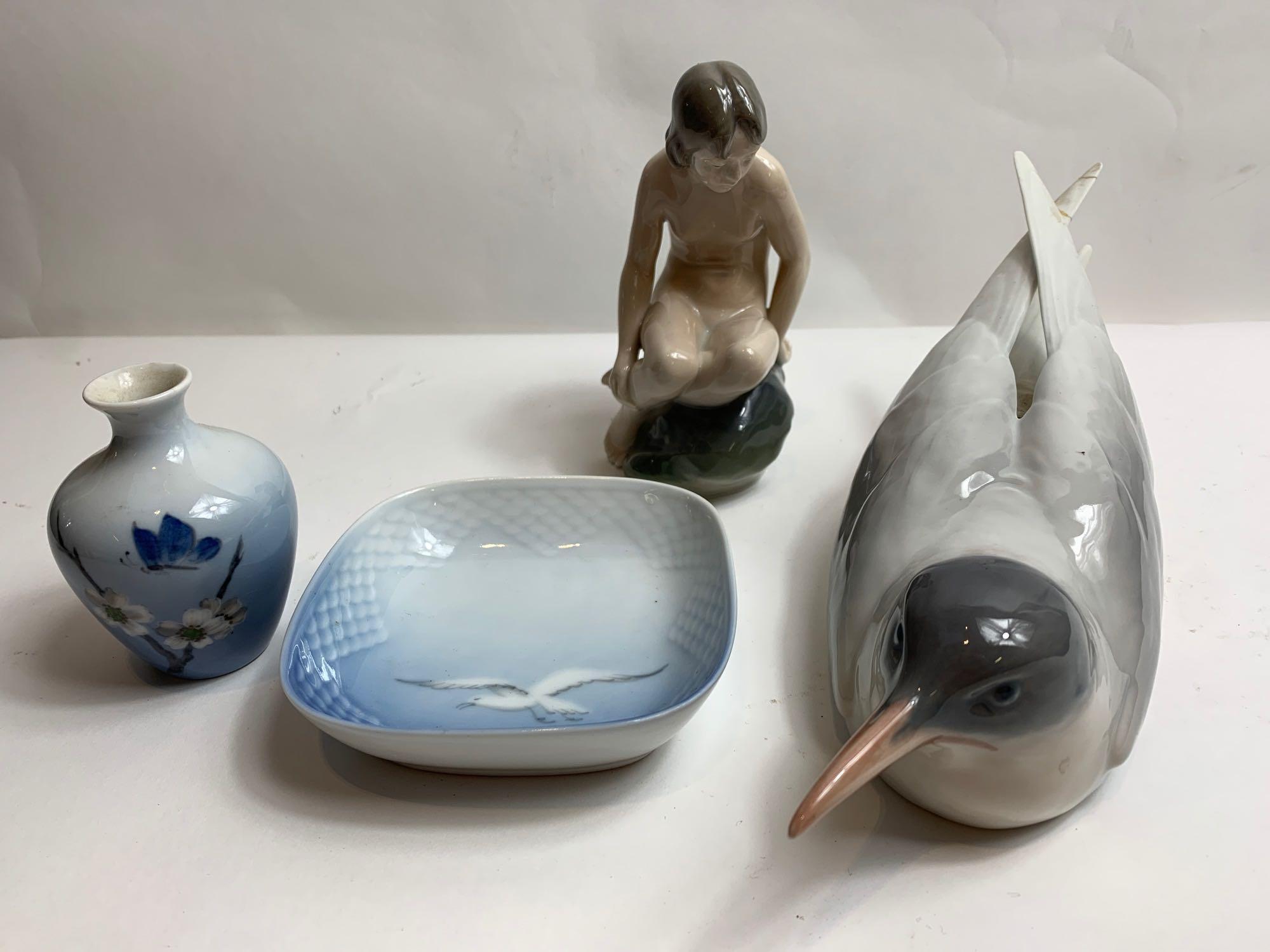 A Royal Copenhagen model of a girl seated on a rock, along with model of a bird, small dish and a