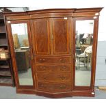 A large walnut wardrobe, with two mirrored sections, four long drawers and two door cupboard