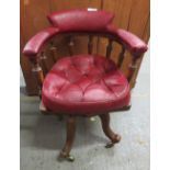 A 20th century oak captain style office chair, part of the back and the seat upholstered in red