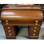 A 20th century mahogany roll top twin pedestal desk, the roll top opening to four pigeon holes