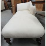 A Victorian chaise longue with shaped back and on four turned mahogany feet and with casters,