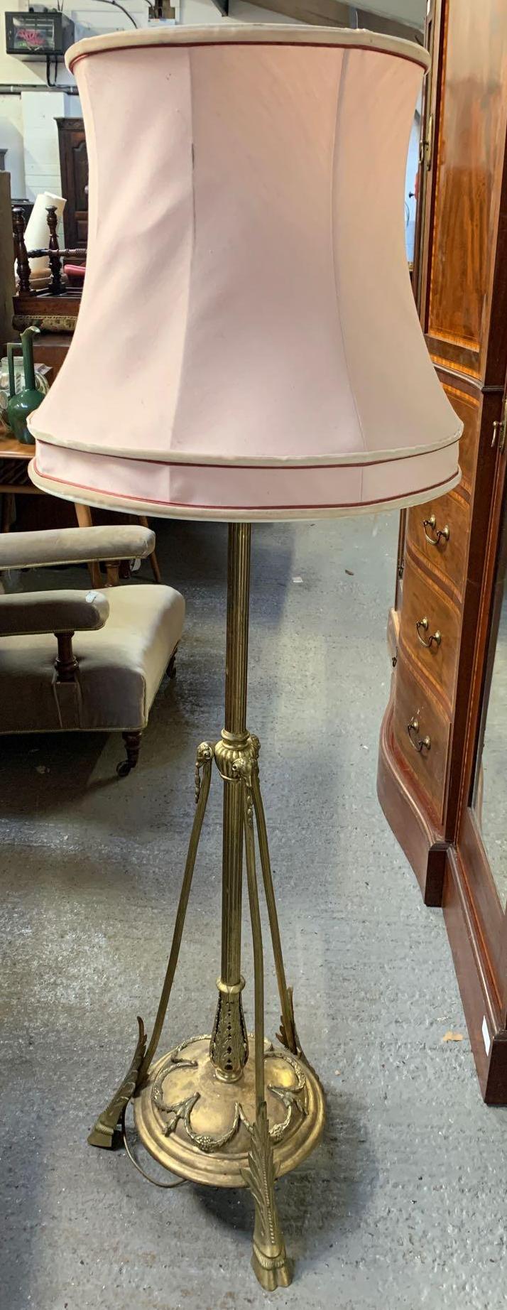 A Victorian brass standard lamp, with a reeded stem support, the circular base with laurel leaf