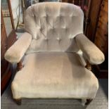 A Victorian low armchair upholstered in a light green velvet, with button back, turned supports to