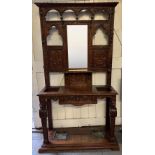 A late Victorian oak hallstand, ornately decorated throughout with carving and cut out sections,