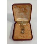 A gold metal pendant of floral design set with pea