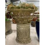 A circular reconstituted stone planter with ring m