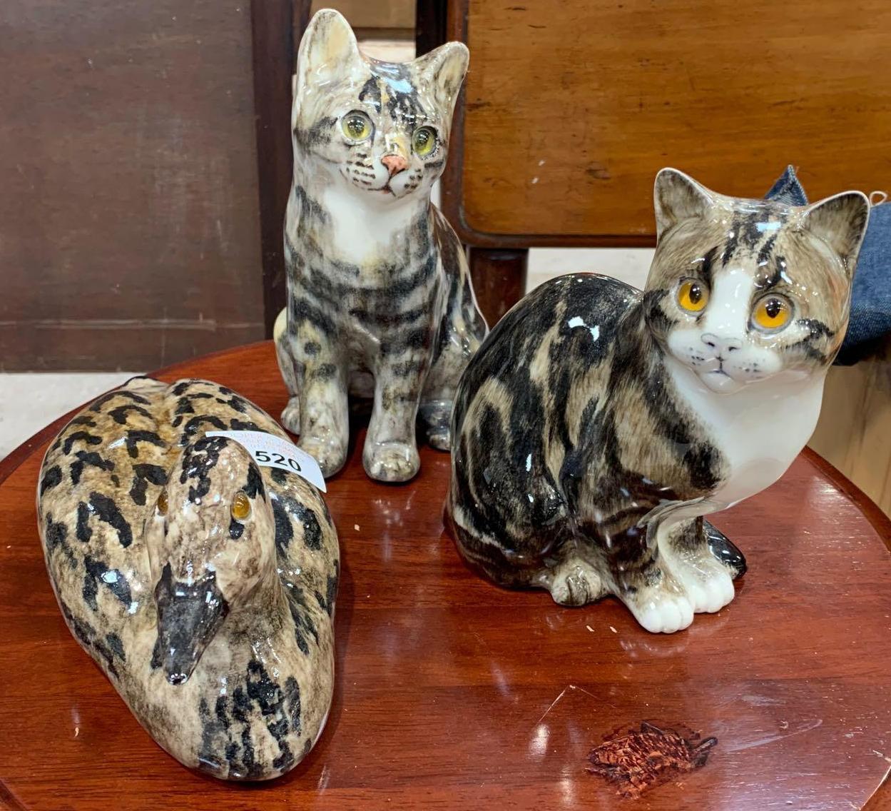 Two ceramic figures of tabby cats in the style of