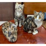 Two ceramic figures of tabby cats in the style of