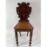 A Victorian mahogany hall chair, with ornately car