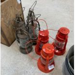 3 red Chalwyn oil lanterns & 4 other oil lanterns.