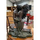 Resin statue of a man & lady kissing.