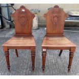 A pair of Victorian mahogany hall chairs