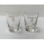 Two small shot glasses each with an etched eagle c
