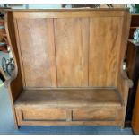 A late 19th Century elm settle the seat lifting to