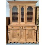 A stripped pine dresser the top with glazed doors