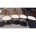 A set of four Ercol stick back chairs with seat cu