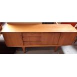A mid century teak sideboard fitted with cupboards