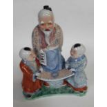 A Chinese glazed figure of a Scholar and two boys