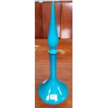 A turquoise glass bottle and tall pointed stopper,